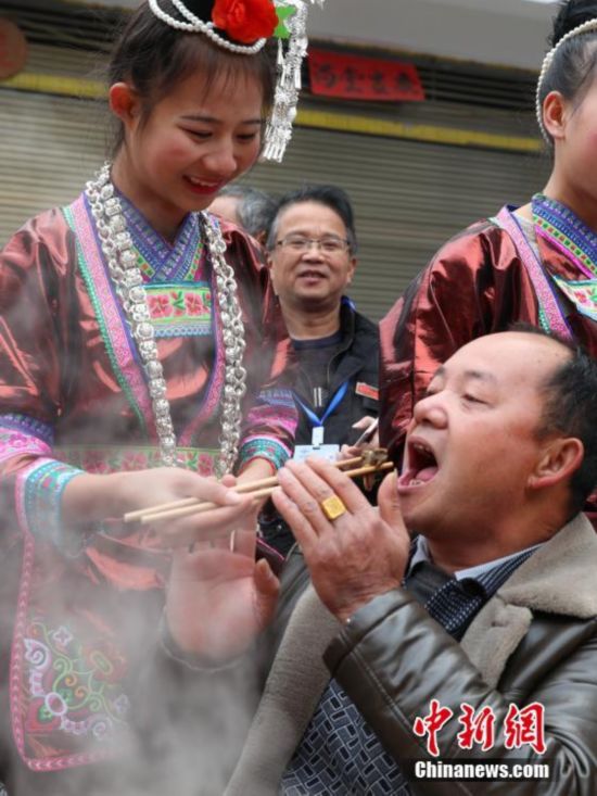 贵州千人牛瘪宴 侗族少女唱敬酒歌喂游客吃食