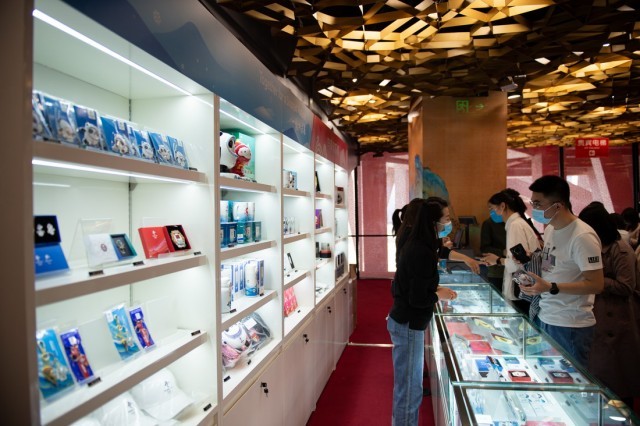 4月20日，“双奥”主题旅游线路体验者在场馆内购买文创产品。